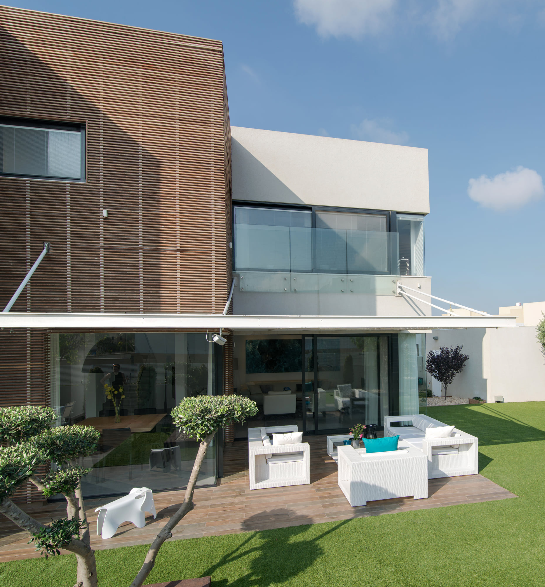 The rear elevation — timber battens wrapping the upper cube, above the glazed front